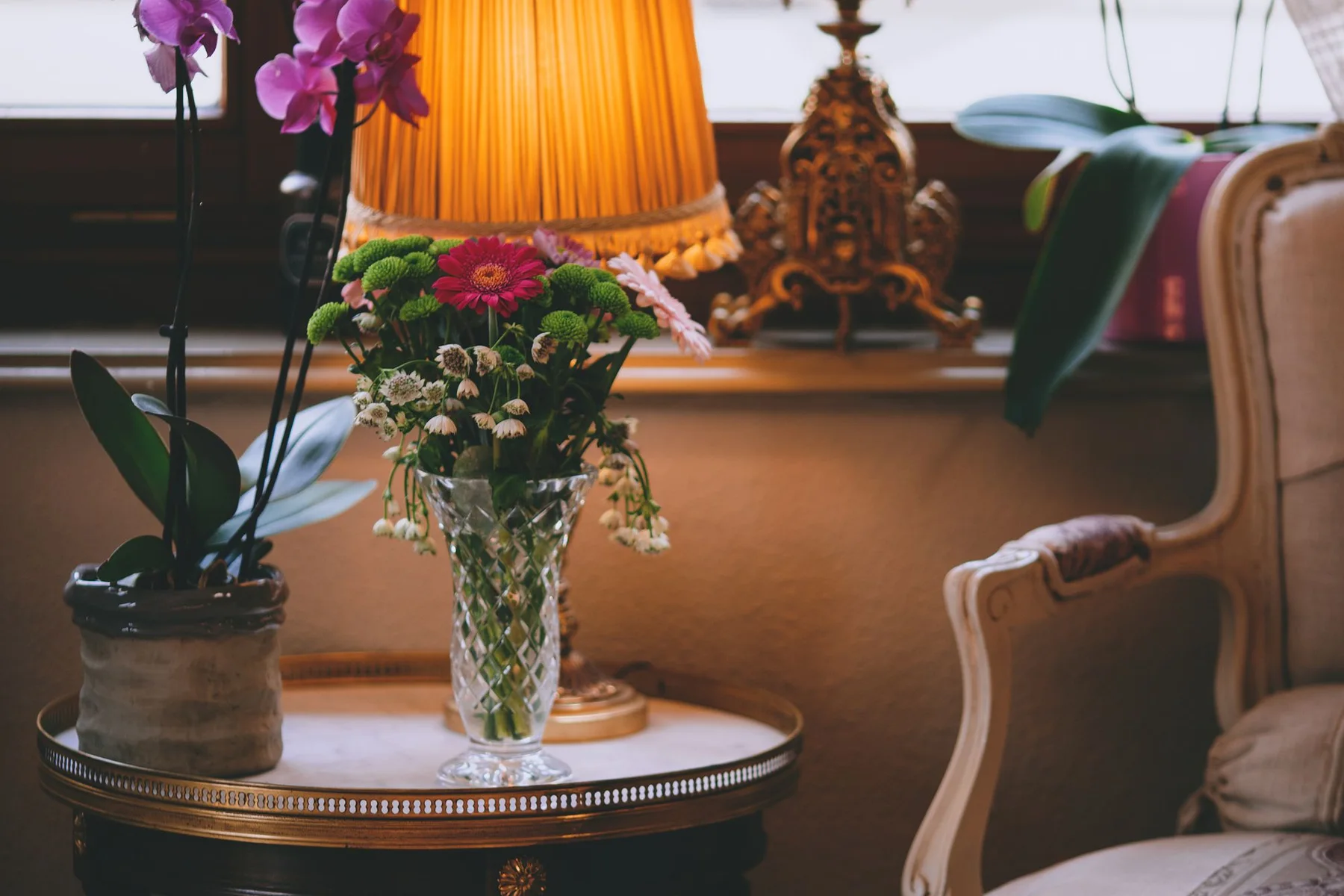 Composição de sala com objetos, luminária e tecidos